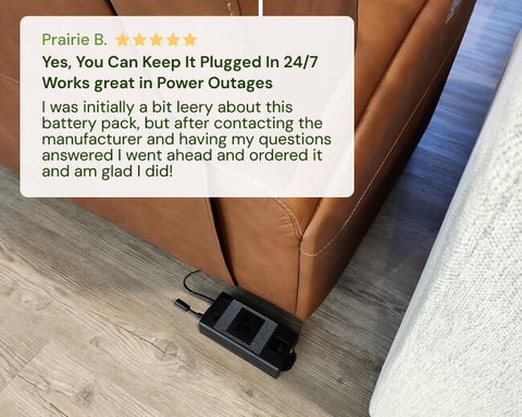 Black battery pack on the floor next to a brown leather couch with a five-star review card above it.