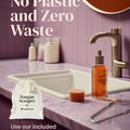 Zero waste bathroom products on a sink with text about plastic-free and zero waste options for YogaMedic's anti-microbial tongue cleaner.