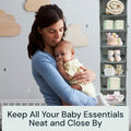 Woman holding a baby in a nursery with Boxy Concepts' foldable shelves of baby supplies.