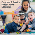 Children playing with toys on the floor in a daycare setting, with a woman smiling.