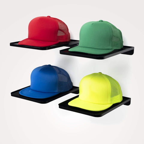 Four colorful caps (red, green, blue, yellow) on black display racks by Boxy Concepts, against a white background
